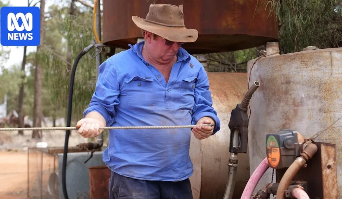 Фермер проверяет уровень топлива в баке в западном Новом Южном Уэльсе