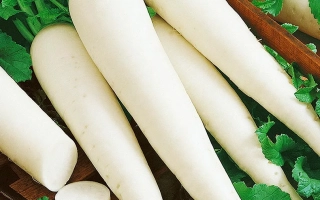 Свежие дайконы на деревянной доске с зелеными листьями - ОМНИ