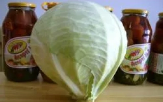 Свежая капуста на деревянной поверхности с банками консервов на заднем плане - МАНДАРИН F1