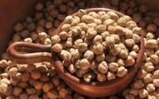 Нут в деревянной лопатке на фоне зерна - ЕС Алунт