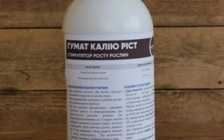 Бутылка с продуктом ГУМАТ КАЛИЮ-АГРО на деревянном фоне