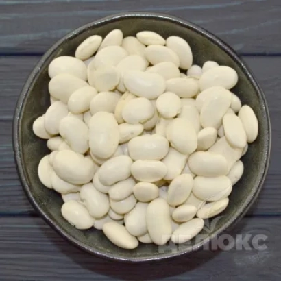 Біла фасоль у чорній мисці на дерев'яному фоні - Контада