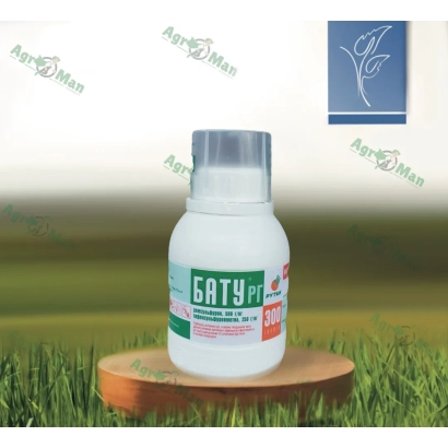 Бутылка гербицида БАТУ на деревянной подставке на фоне травы