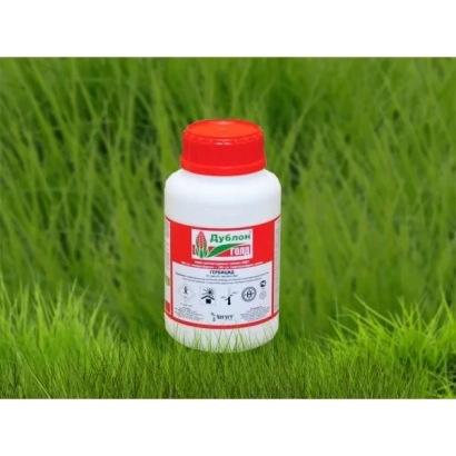 Bottle of herbicide Dublon Gold on green grass