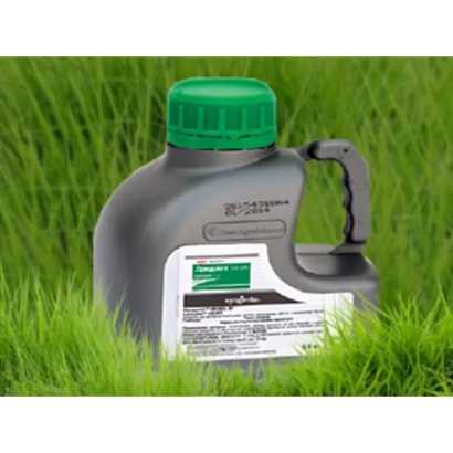 Флакон гербицида Ланселот 240 г/л + ПАР Стаф на фоне зеленой травы