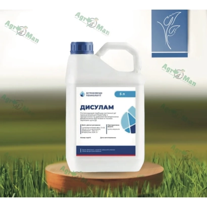 Бутылка с гербицидом Дисулам на деревянном подставке на фоне травы.