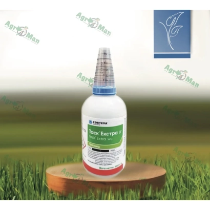 Бутылка с гербицидом Агро-Эксперт на деревянной подставке на фоне травы - Таскус (Taskus)