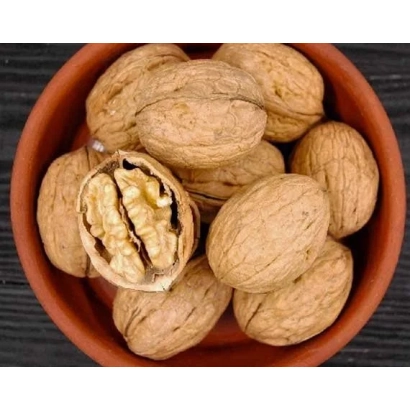 Грецкие орехи в керамической миске, один разломлен для демонстрации ядра - Топоривский