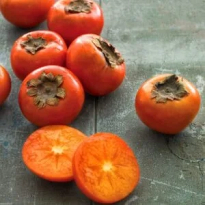 Свіжі хурми на дерев'яній поверхні, одна розрізана навпіл - Подарунок Осені