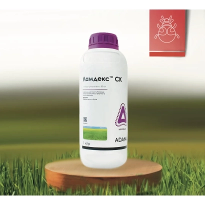 Бутылка с инсектицидом Ламдекс СК на деревянной подставке на фоне травы.