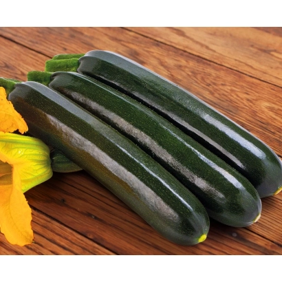 Три темно-зеленых кабачка с желтым цветком на деревянной поверхности - САЛЬВАДОР