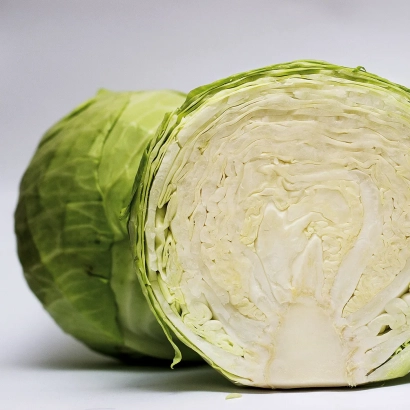Свежая капуста, нарезанная пополам, на белом фоне - Ритейл