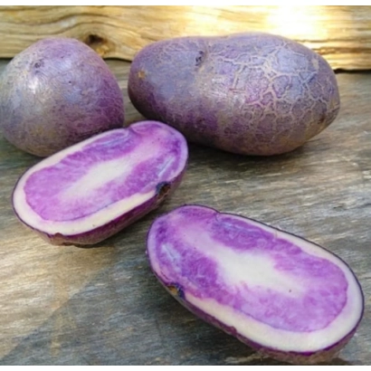 Клубні картоплі Олександрит з розрізом, що демонструють фіолетову м'якоть на дерев'яній поверхні.