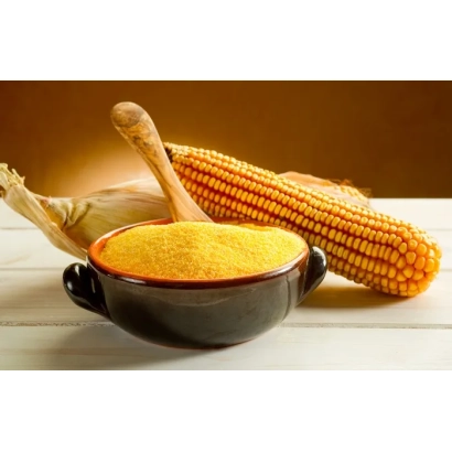 Желтая кукурузная крупа в черной миске рядом с початком кукурузы - КЛУНИ