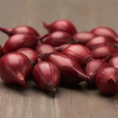 Красные луковицы сорта Гарнет на деревянной поверхности