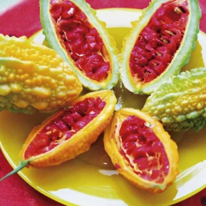 Разрезанные плоды момордики желтого дракона на желтой тарелке - Желтый Дракон