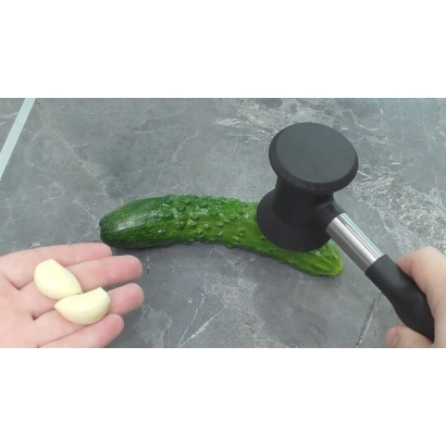 Огурец Хаммер с молотком и долькой чеснока на фоне
