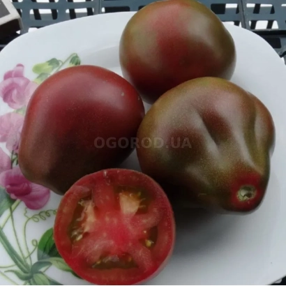 Томаты сорта ДЖАГА на тарелке, один разрезан пополам