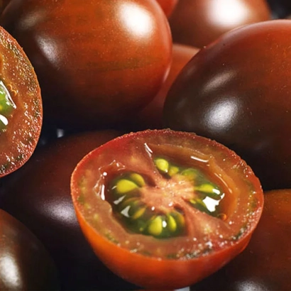 Черные помидоры, один разрезан пополам, видны семена - КМ 5512