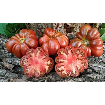 Червоні помідори сорту Квітка на дерев'яній поверхні, один розрізаний навпіл