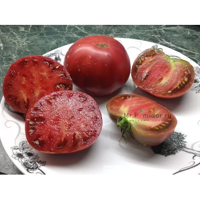 Срезанные томаты сорта Никсарти на белой тарелке