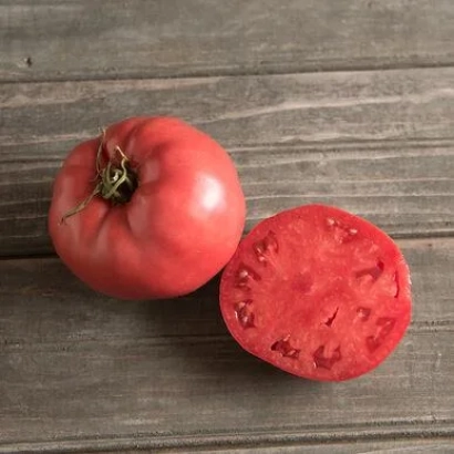 Свежий красный томат на деревянной поверхности, один целый и один разрезанный пополам - РОСЕ