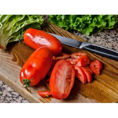 Свежие красные томаты на деревянной доске с зеленью на заднем плане - ТУРИНО