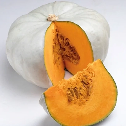 White pumpkin with a cut section showing orange flesh and seeds. - Nelson