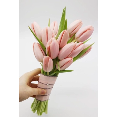 Букет нежно-розовых тюльпанов в розовой бумаге, держимый рукой на белом фоне. - Нежность