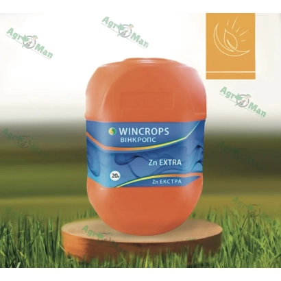 Оранжевая бутылка удобрения WINCROPS ZINC EXTRA на деревянной подставке на фоне зеленой травы. - Микросид Цинк Супер