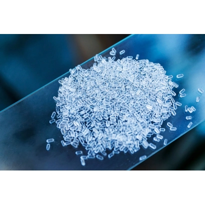 Білі кристалічні гранули добрива СульфоМаг на прозорій поверхні