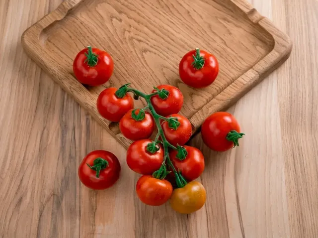 Ripe tomato fruits of the Typhoon F1 variety on a wooden board