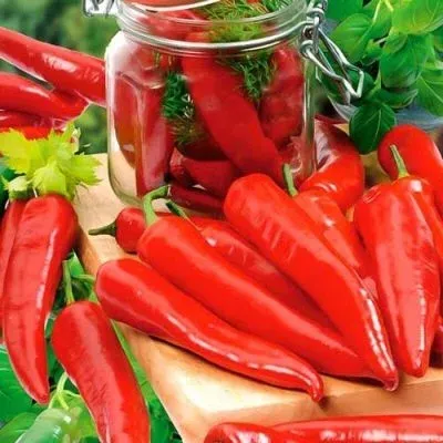 Червоні перець сорту Астраханський 147 у скляній банці та на дерев'яній дошці